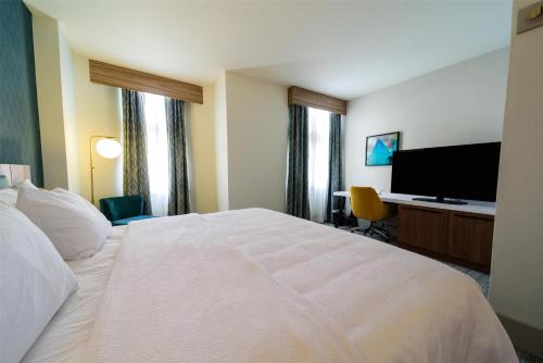 a hotel room with a bed and a flat screen tv at Hilton Garden Inn Dayton Downtown in Dayton