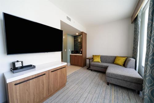 a living room with a flat screen tv and a couch at Hilton Garden Inn Dayton Downtown in Dayton