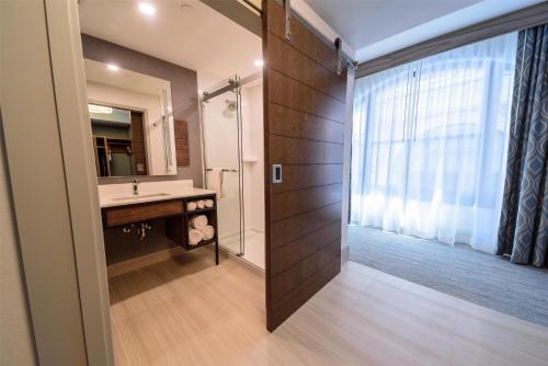 a bathroom with a sink and a shower with a mirror at Hilton Garden Inn Dayton Downtown in Dayton