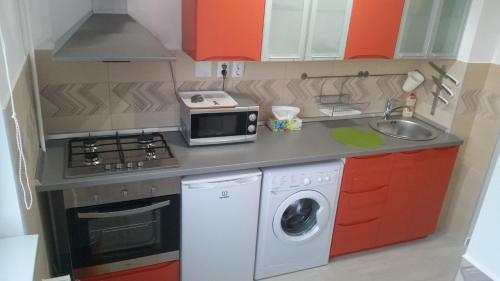 a small kitchen with a microwave and a washing machine at Universitate Residence in Bucharest