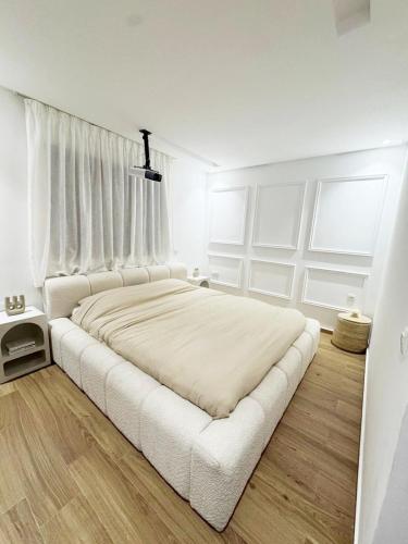 马拉喀什Appartement de Luxe 3 Chambres avec piscine au centre的白色卧室配有一张带白色窗帘的大床