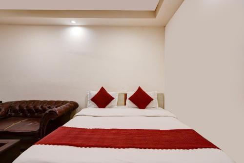 a bedroom with a bed and a leather couch at Birr Residency - Near Nizamuddin in New Delhi