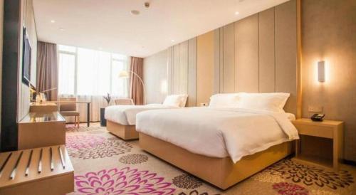 a hotel room with two beds and a desk at Lavande Hotel Zhaoqing government Dinghu Mountain Scenic Spot in Zhaoqing