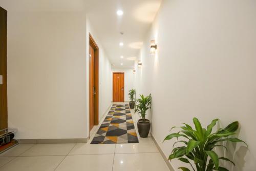 un pasillo con plantas y suelo a cuadros en FabHotel Pride Inn - Nr TCS Deccan Park, Hitech City, en Hyderabad