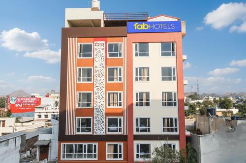 a tall building with a sign on top of it at FabHotel Prime The Royal Galaxy in Udaipur