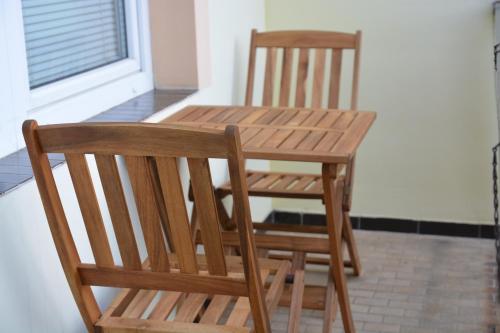 a wooden table and chairs sitting next to a window at Wellness Vila Bohemia in Prague