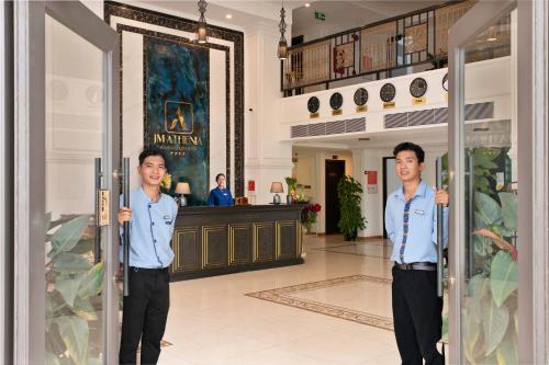 two men standing in front of a door at JM Hoi An Beach Hotel - Free Shuttle Car To Old Town in Hoi An