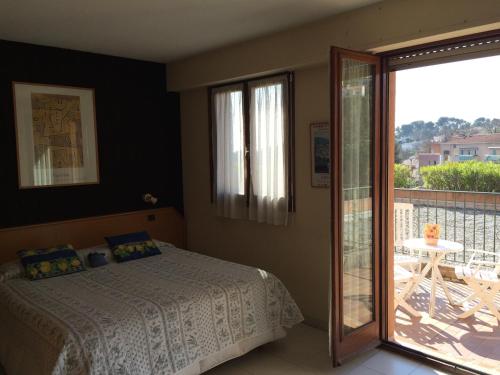 a bedroom with a bed and a balcony at Mas de Vence - Hotel-Restaurant in Vence