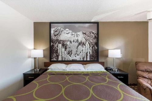 a bed with two lamps and a painting on the wall at Super 8 By Wyndham Wayne in Wayne