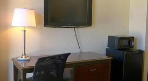 a desk with a television and a desk with a chair at Lemon Heights Inn in Tustin