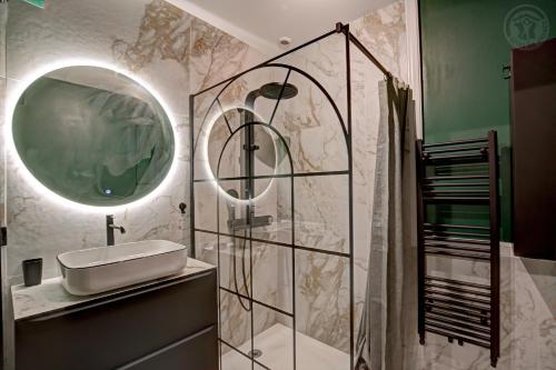 a bathroom with a sink and a glass shower at Château Philip in Saint-Genest-Lerpt