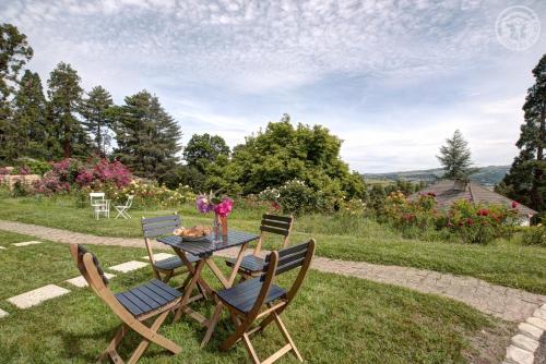 a table with two chairs and a table with flowers on it at Château Philip in Saint-Genest-Lerpt