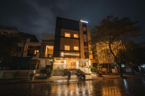 a building on a street in the rain at night at FabHotel Shree Ram Palace in Indore