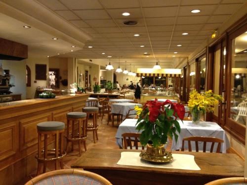 un restaurant avec des tables et des chaises avec des fleurs dessus dans l'établissement Mas de Vence - Hotel-Restaurant, à Vence