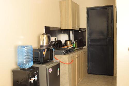 a kitchen with a black refrigerator and a stove at Reggyhomes in Nairobi