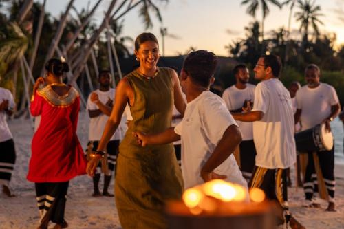 a group of people standing on the beach at Sun Siyam Iru Veli - 24 Hours Premium All-Inclusive with Free Transfers in Dhaalu Atoll