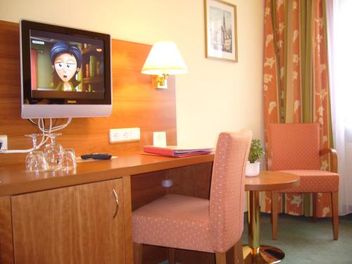 a hotel room with a desk with a television on it at Hotel Alter Kranen in Würzburg