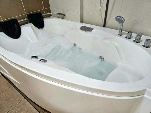 a bath tub filled with water in a bathroom at Paragon Water Themepark Suites Melaka by GGM in Melaka