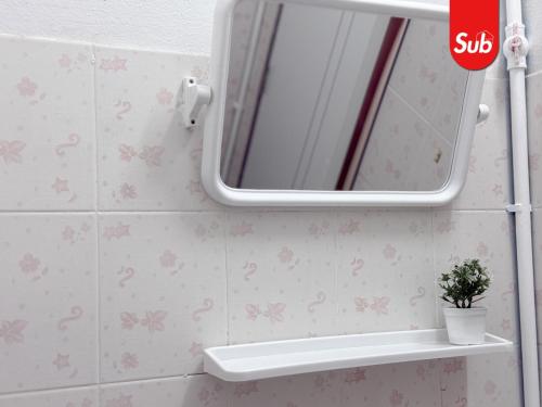 a mirror in a bathroom with pink flowers on the wall at Happy One-Bedroom Stay in Hat Yai in Ban Thung Ngai