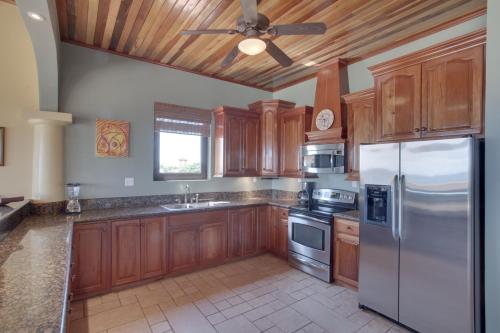 a kitchen with wooden cabinets and a ceiling fan at Coco Beach Resort in San Pedro