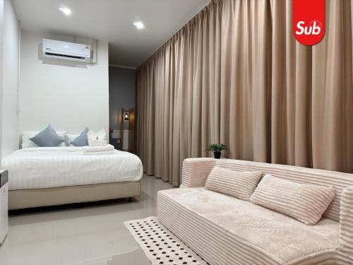 a hotel room with a bed and a couch at Happy One-Bedroom Stay in Hat Yai in Ban Thung Ngai
