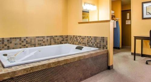 a large bath tub in a room with a table at Quality Inn & Suites Kimberly - Appleton East in Kimberly