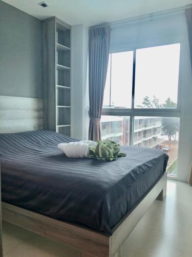 a bed in a bedroom with a large window at GrandBlue Condo 506 in Ban Tha Fat