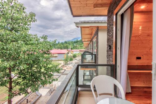 a balcony with two chairs and a view of a street at Shivalaya Retreat - A River Side Resort in Manāli