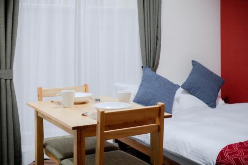 een tafel en stoelen met een bed in een kamer bij Noir Toji Inn in Kyoto