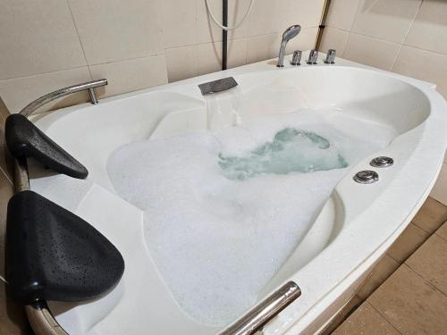 a bath tub filled with water in a bathroom at Melaka Town Area Top 1 Family Lovers Water Themepark Suites By GGM in Melaka