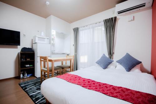 een slaapkamer met een bed, een tafel en een bureau bij Noir Toji Inn in Kyoto