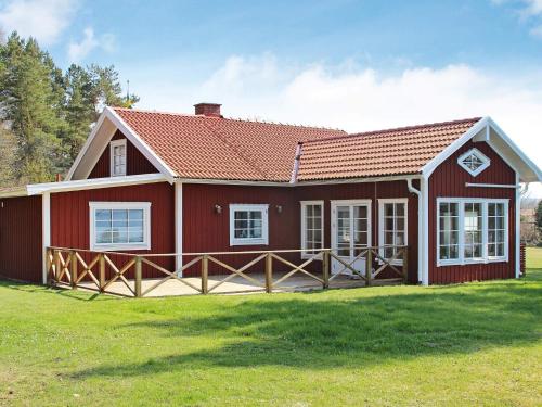 a red house with a red roof on a grass field at 5 person holiday home in MARIESTAD-By Traum in Lugnås