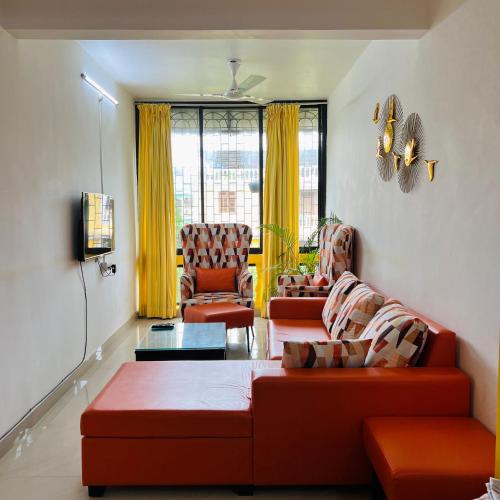 a living room with two couches and two chairs at Cozy Corner - Tropical 2BHK pool pad in Varca