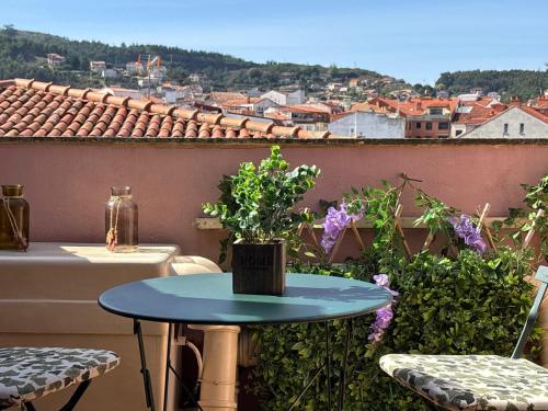 a table on a balcony with a view of a city at Hoibai Raiña, A un paso de la playa y del casco antiguo in Baiona