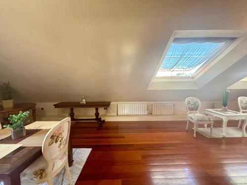 a living room with a skylight and a table and chairs at Hoibai Raiña, A un paso de la playa y del casco antiguo in Baiona