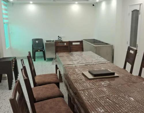 a room with a table and chairs and a kitchen at Hotel Anji Solan Hills in Solan