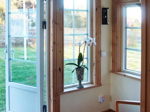 a vase with white flowers in a window at 5 person holiday home in MARIESTAD-By Traum in Lugnås