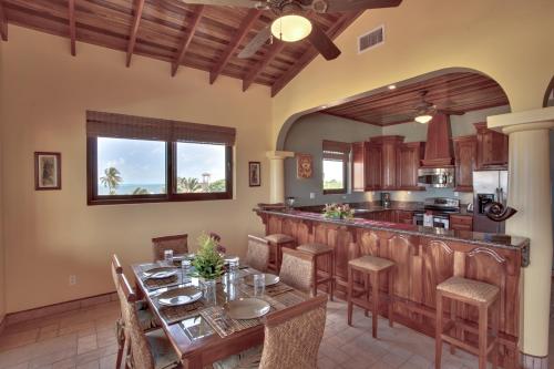 a kitchen with a dining table and a bar at Coco Beach Resort in San Pedro
