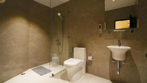 un baño con inodoro y lavabo en Hotel Kuber, en Guwahati