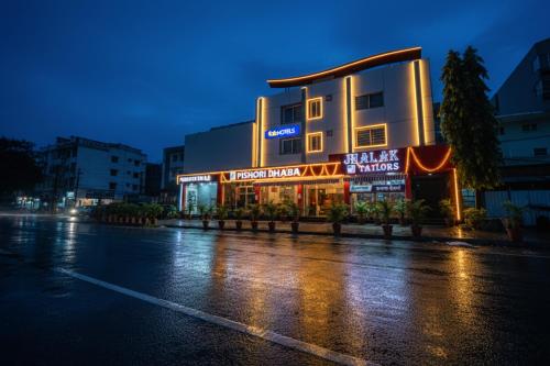a building with neon signs on the side of a street at FabHotel Pishori in Indore
