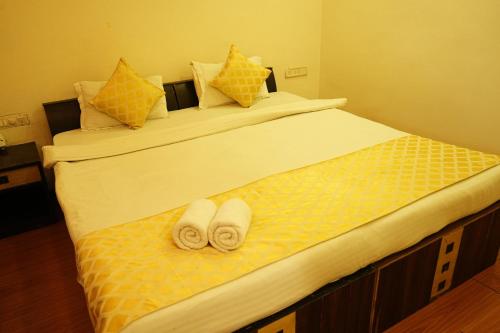 a bed with two towels and pillows on it at HOTEL SUN GREEN in Bhubaneshwar