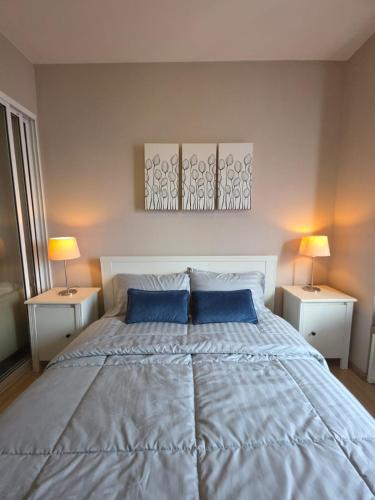 a bedroom with a large bed with blue pillows at FavStay Ramkhamhaeng, Stylish 1BR Bangkok in Bangkok