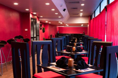 a dining room with red walls and tables and chairs at Barceló Ixtapa - All Inclusive in Ixtapa