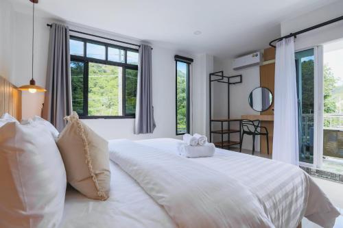 ein Schlafzimmer mit einem großen weißen Bett mit zwei ausgestopften Tieren in der Unterkunft Wink Hill 1 Penthouse Patong 4 Bedrooms in Patong Beach