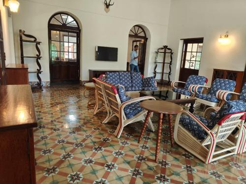 a room with chairs and a table and a tv at The Estate Bay by Z Vacations in Gonikoppal
