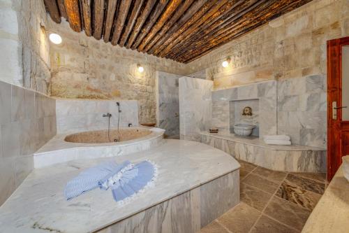 a large bathroom with a tub and a toilet at MDC Cave Hotel in Urgup