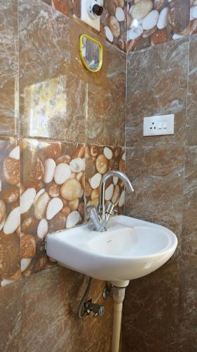 a bathroom with a sink and a stone wall at Happy Villa By Eden Luxury Stay in Ooty