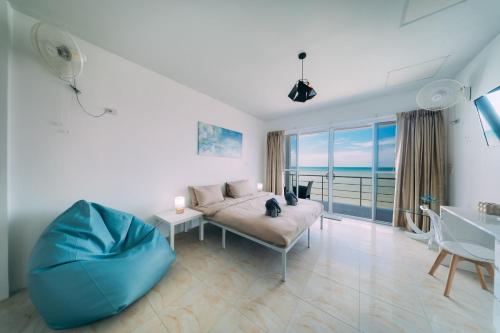 a living room with a couch and a view of the ocean at Phaladise Beach Villa at Phala Beach, Ban Chang in Rayong