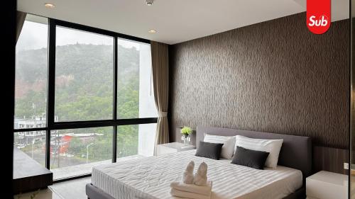 Ban Thung NgaiにあるElegant Private Suite Room in Hat Yaiの大きな窓のあるベッドのある寝室
