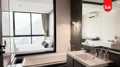 Ban Thung NgaiにあるElegant Private Suite Room in Hat Yaiの浴槽と洗面台と窓のあるバスルーム